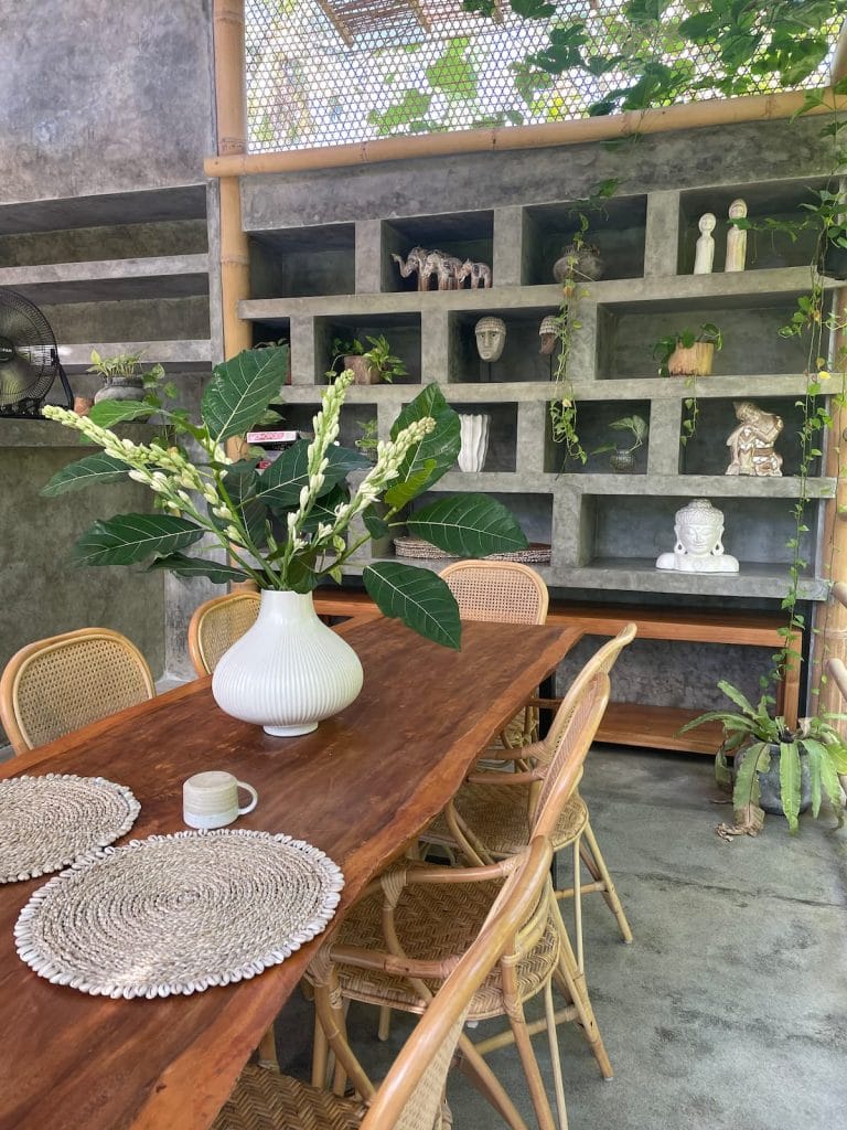 Dining area with a large wooden table and polished cement wall in background